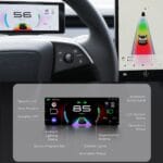 Car interior with a digital instrument cluster showing 85 km/h, lane guidance colors, and ambient lighting indicators.