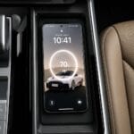 Phone resting in a car's center console showing 70% battery with a circular charging animation and a car graphic on screen.